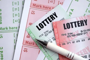 Lottery tickets and betting slips with numbered draw selections and a pen, illustrating lottery gambling and ticket purchases. Massachusetts Lottery faces criticism over youth appeal